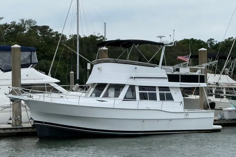 Slide: The Image of 1998 Mainship 350 Trawler docked at marina, featuring classic white design. - 1