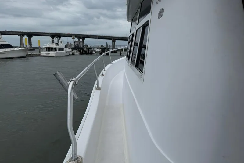 Slide: The Image of 1998 Mainship 350 Trawler docked near a bridge on a cloudy day. - 11