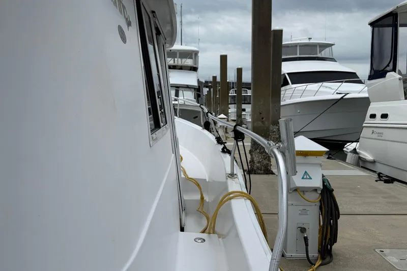 Slide: The Image of 1998 Mainship 350 Trawler docked at marina with other boats. - 12