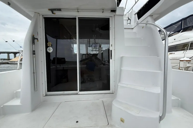 Slide: The Image of 1998 Mainship 350 Trawler with sliding glass doors and exterior staircase, docked at marina. - 18