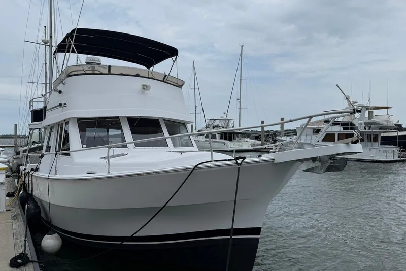 Slide: The Image of 1998 Mainship 350 Trawler docked at marina under cloudy sky. - 2