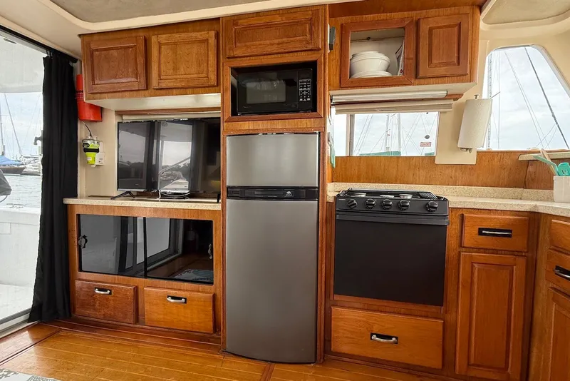 Slide: The Image of Interior of 1998 Mainship 350 Trawler with kitchen appliances and wooden cabinetry. - 22