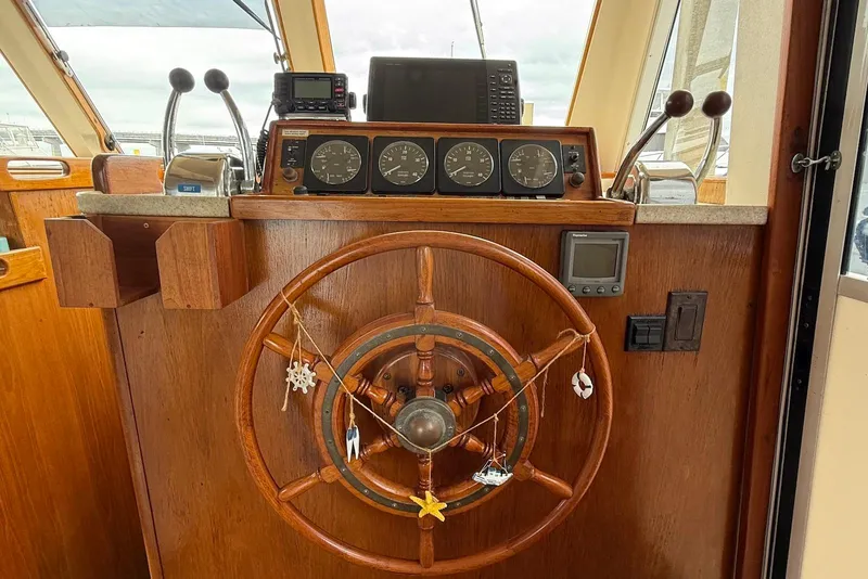 Slide: The Image of 1998 Mainship 350 Trawler helm with wooden wheel and navigation instruments. - 23