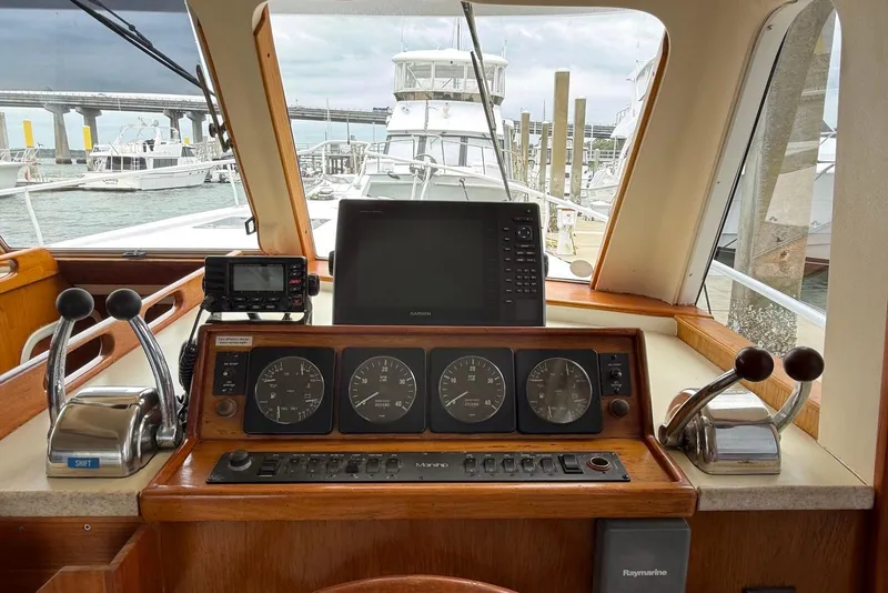 Slide: The Image of 1998 Mainship 350 Trawler helm with navigation instruments and controls, docked at marina. - 24