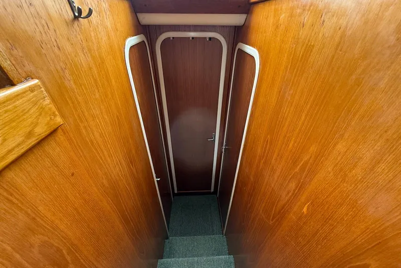 Slide: The Image of Interior view of 1998 Mainship 350 Trawler, featuring wooden walls and a central door. - 26
