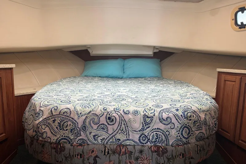 Slide: The Image of Cozy cabin bedroom in 1998 Mainship 350 Trawler with patterned bedding and wooden cabinets. - 27