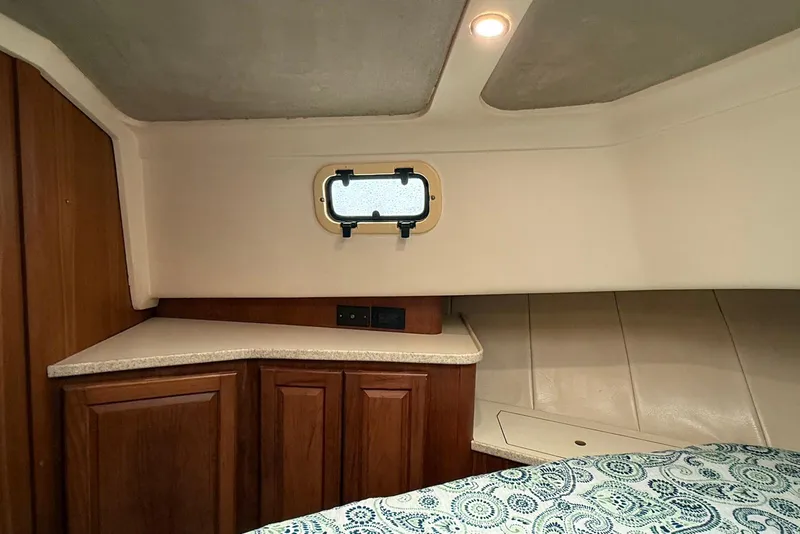 Slide: The Image of 1998 Mainship 350 Trawler cabin interior with wood cabinetry and small window. - 28