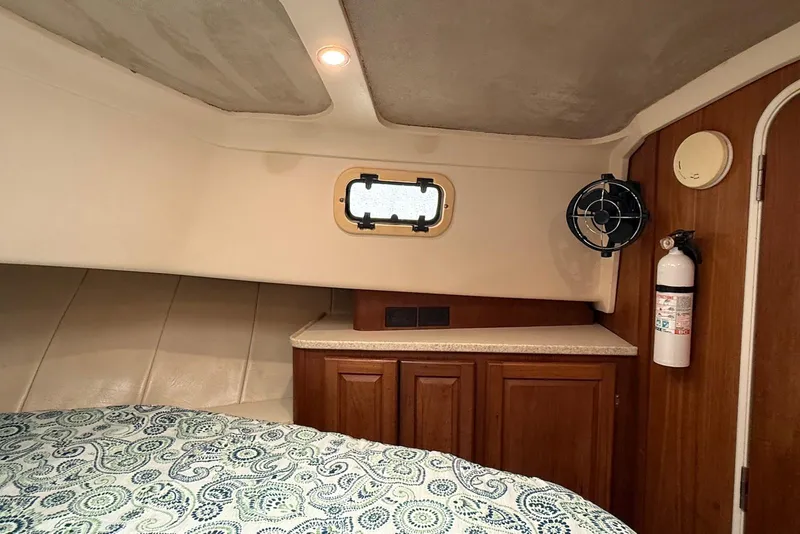 Slide: The Image of Cozy cabin interior of 1998 Mainship 350 Trawler with bed, cabinet, and porthole. - 29
