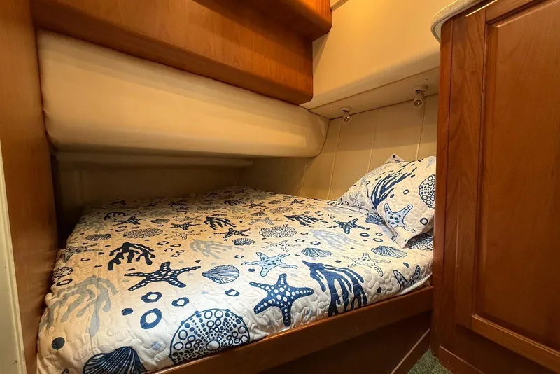 Slide: The Image of Cozy cabin bed in 1998 Mainship 350 Trawler with nautical-themed bedding. - 32