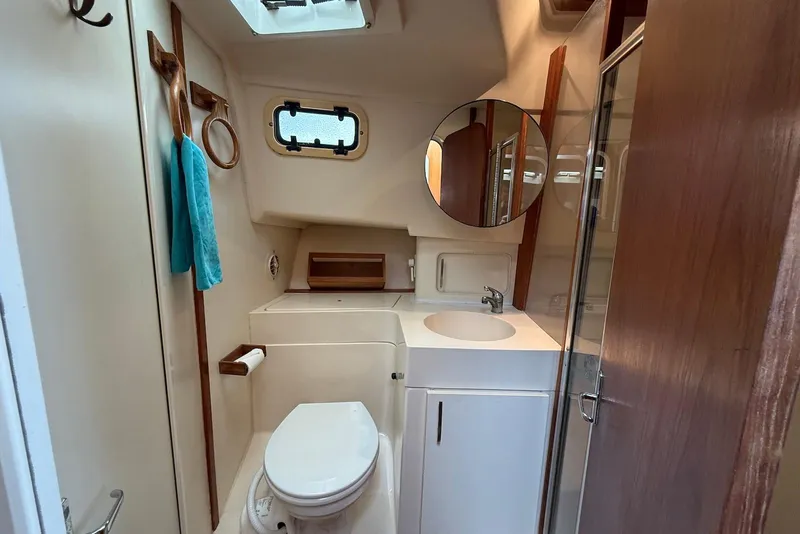 Slide: The Image of Bathroom interior of 1998 Mainship 350 Trawler with sink, toilet, and mirror. - 34