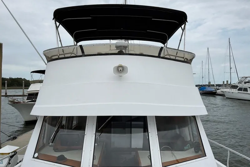 Slide: The Image of 1998 Mainship 350 Trawler docked at marina, front view with canopy. - 4