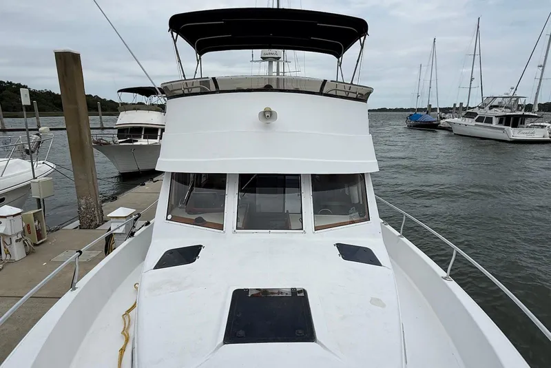 Slide: The Image of 1998 Mainship 350 Trawler docked at marina, surrounded by other boats. - 5