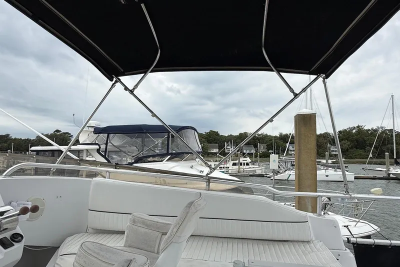 Slide: The Image of 1998 Mainship 350 Trawler at marina, featuring spacious seating and canopy. - 8