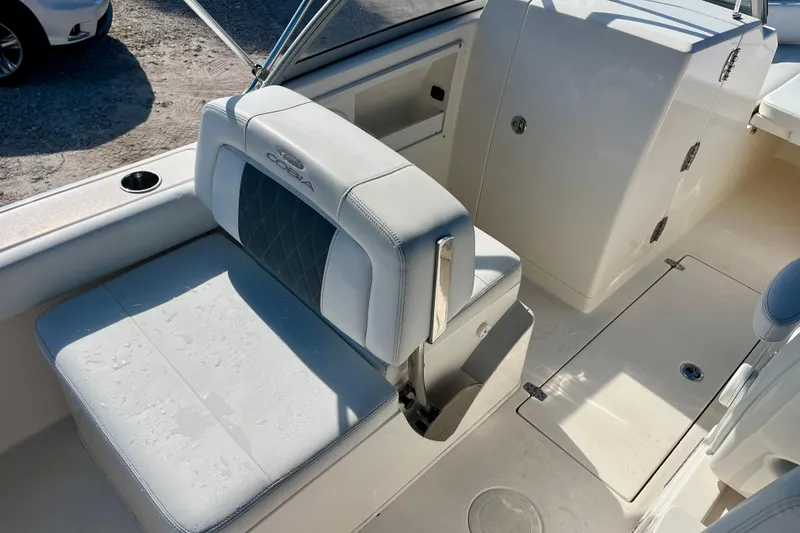Slide: The Image of 2023 Cobia 220 Dual Console boat interior with cushioned seating and storage compartments. - 12