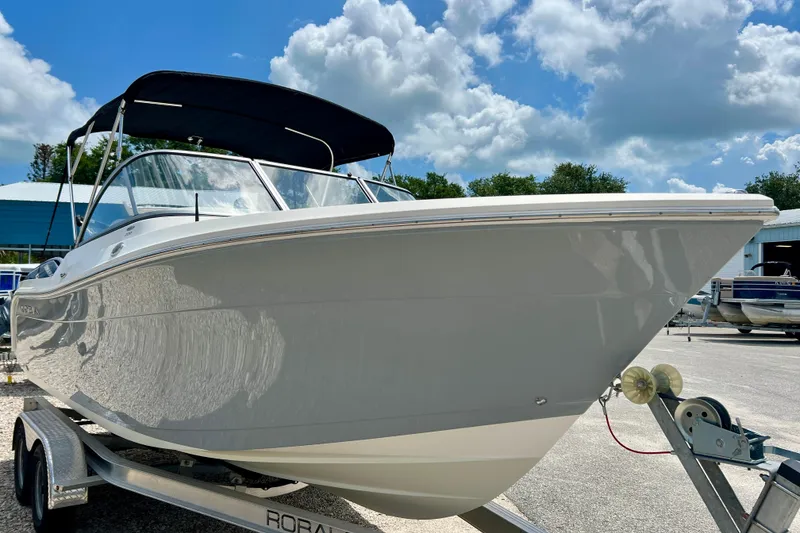 Slide: The Image of 2023 Cobia 220 Dual Console boat on trailer under blue sky. - 6