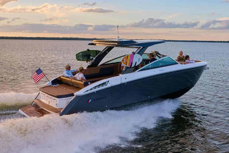 Slide: The Image of Manufacturer Provided Image: 2025 Cobalt R33 Surf boat cruising on a lake at sunset with passengers onboard. - 20