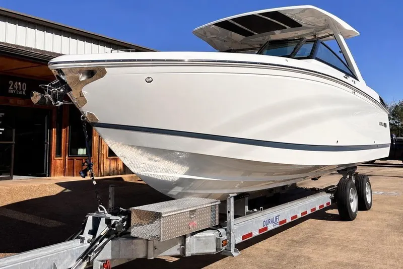 Slide: The Image of 2025 Cobalt R33 Surf boat on trailer outside building. - 4