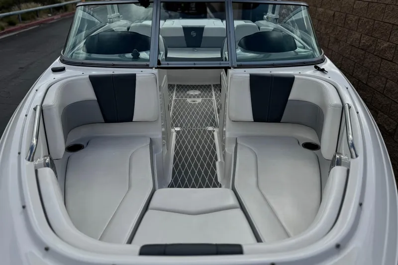 Slide: The Image of 2020 Chaparral 21 Surf boat interior with white and gray seating, diamond-patterned flooring. - 10