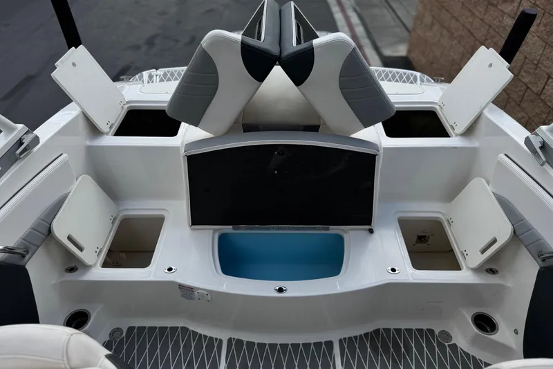 Slide: The Image of 2020 Chaparral 21 Surf boat interior with open storage compartments and seating. - 20