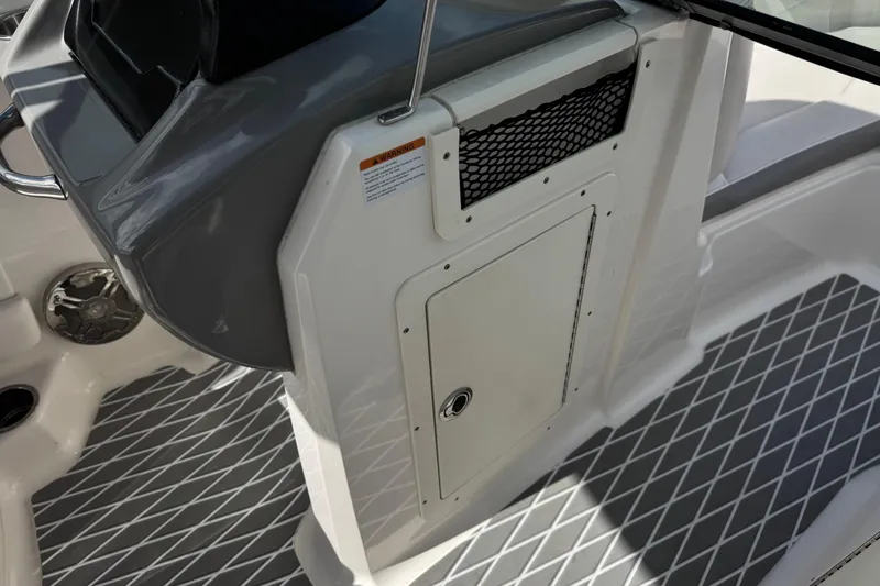 Slide: The Image of Interior view of a 2020 Chaparral 21 Surf boat, featuring storage compartment and textured flooring. - 26