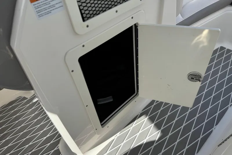 Slide: The Image of Open storage compartment on 2020 Chaparral 21 Surf boat with diamond-patterned flooring. - 27