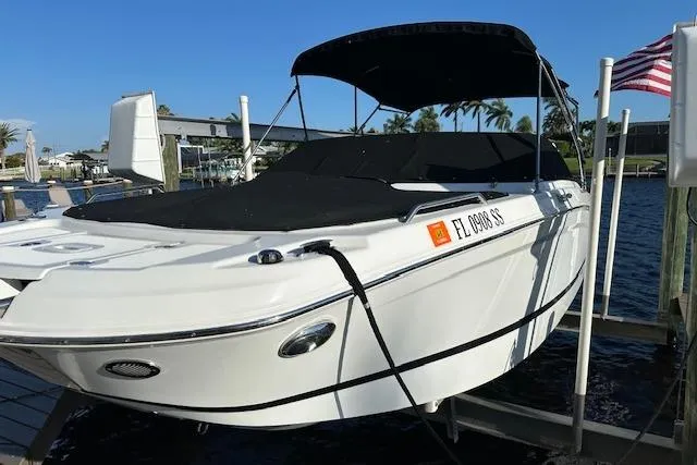 Slide: The Image of 2020 Four Winns HD220 OB boat docked with black canopy and cover. - 17