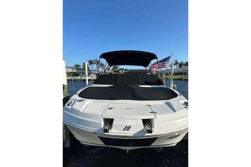 Slide: The Image of 2020 Four Winns HD220 OB boat docked with American flag, sunny day. - 18