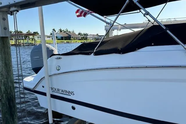 Slide: The Image of 2020 Four Winns HD220 OB boat docked by waterfront homes. - 19
