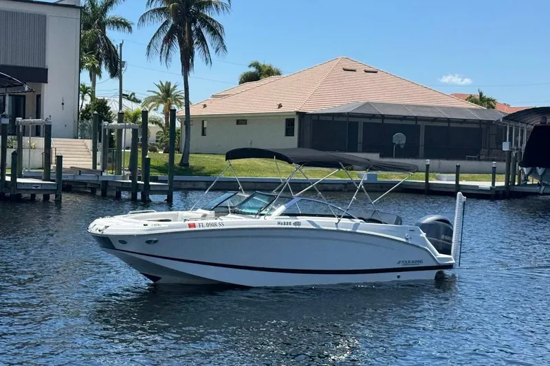 Slide: The Image of 2020 Four Winns HD220 OB boat docked near waterfront homes with palm trees. - 3