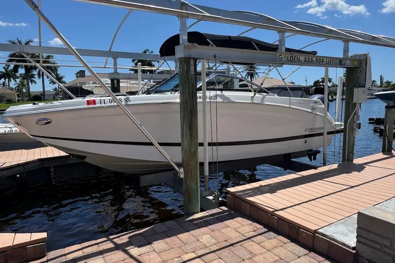 Slide: The Image of 2020 Four Winns HD220 OB boat on lift at marina dock. - 8