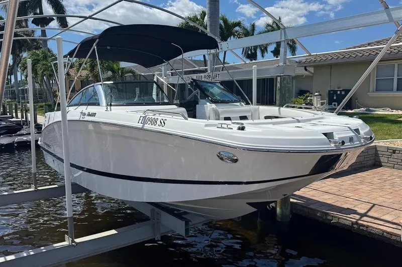 Slide: The Image of 2020 Four Winns HD220 OB boat on lift, featuring sleek design and black canopy. - 9
