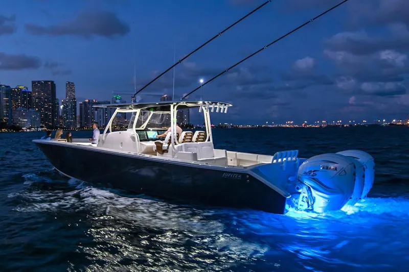 Slide: The Image of Manufacturer Provided Image: 2026 Jupiter 43 boat cruising at night with city skyline and glowing blue lights. - 3