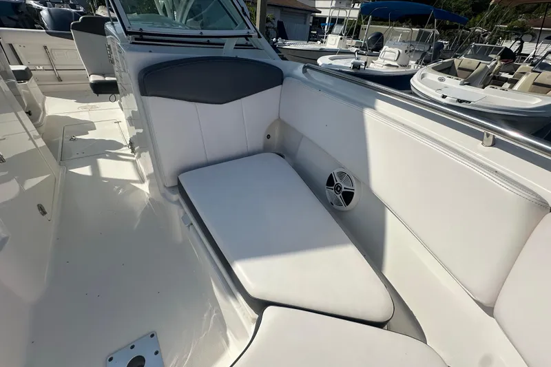 Slide: The Image of 2018 Robalo R247 Dual Console boat interior with white seating and speaker. - 10