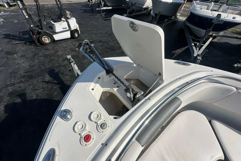 Slide: The Image of 2018 Robalo R247 Dual Console boat with open anchor compartment and visible controls. - 12