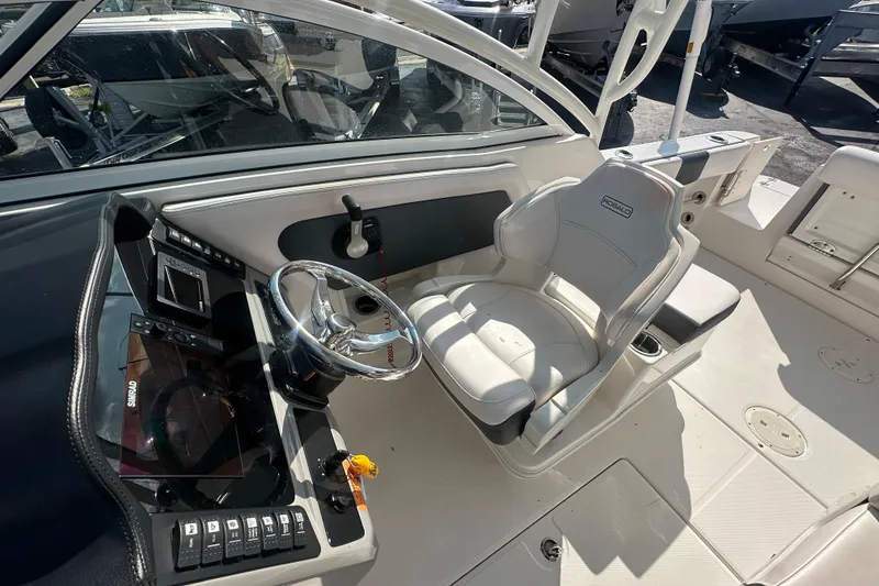 Slide: The Image of 2018 Robalo R247 Dual Console boat interior with steering wheel and captain's chair. - 14