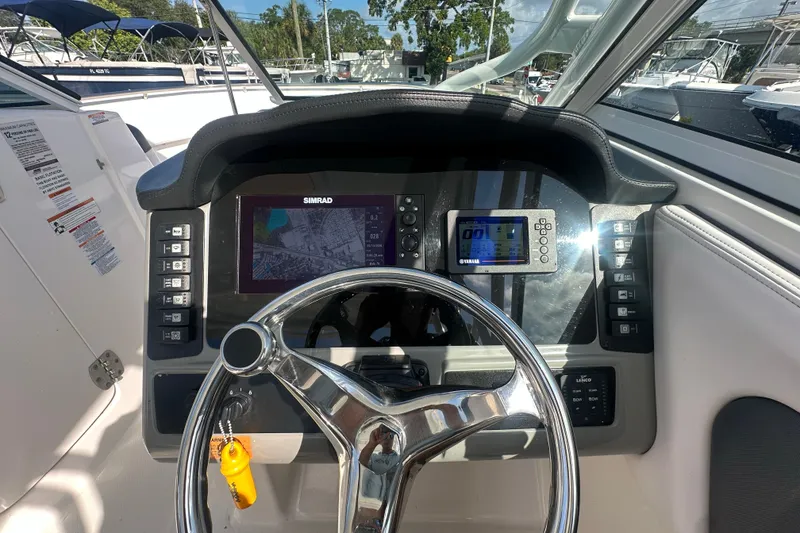 Slide: The Image of 2018 Robalo R247 Dual Console dashboard with steering wheel, Simrad display, and Yamaha controls. - 15