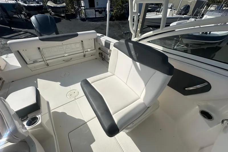 Slide: The Image of 2018 Robalo R247 Dual Console boat interior with seating and cup holders. - 17