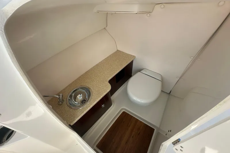 Slide: The Image of 2018 Robalo R247 Dual Console boat interior with sink and toilet. - 19