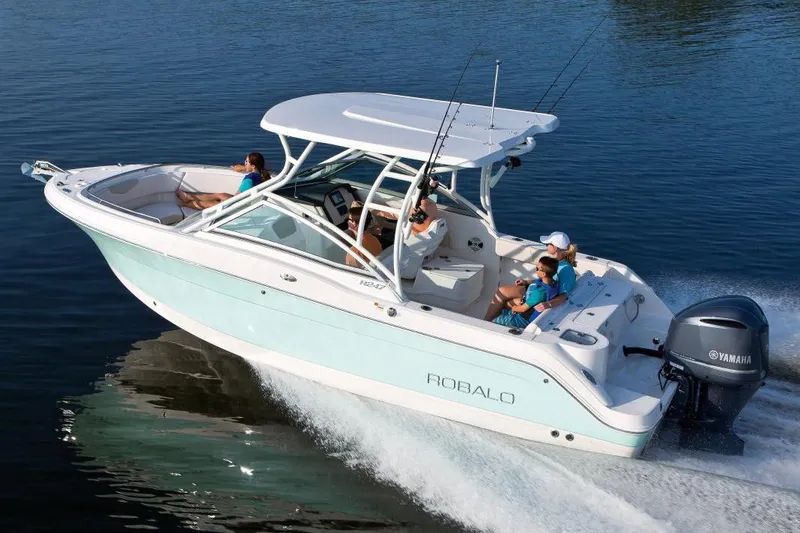 Slide: The Image of Manufacturer Provided Image: 2018 Robalo R247 Dual Console boat cruising on water with passengers. - 24