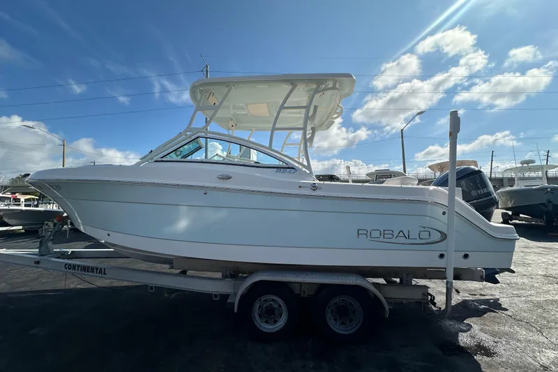 Slide: The Image of 2018 Robalo R247 Dual Console boat on trailer under blue sky. - 5