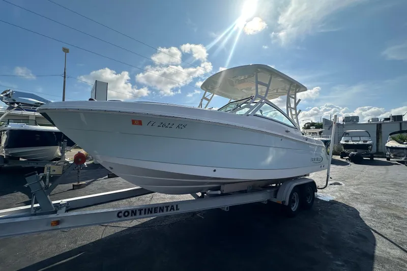Slide: The Image of 2018 Robalo R247 Dual Console boat on trailer under sunny sky. - 6