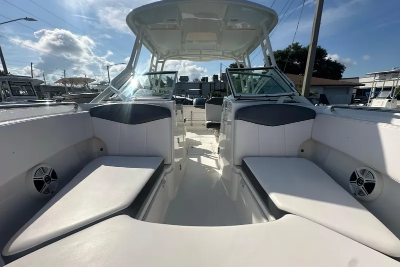Slide: The Image of 2018 Robalo R247 Dual Console boat interior with seating and speakers under a clear sky. - 8
