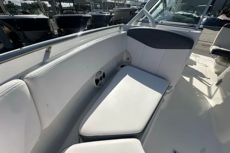 Slide: The Image of 2018 Robalo R247 Dual Console boat interior with white seating and speaker. - 9