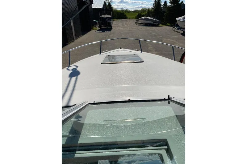 Slide: The Image of 1995 Chaparral 2335 SS boat deck view with clear sky and parked boats. - 5