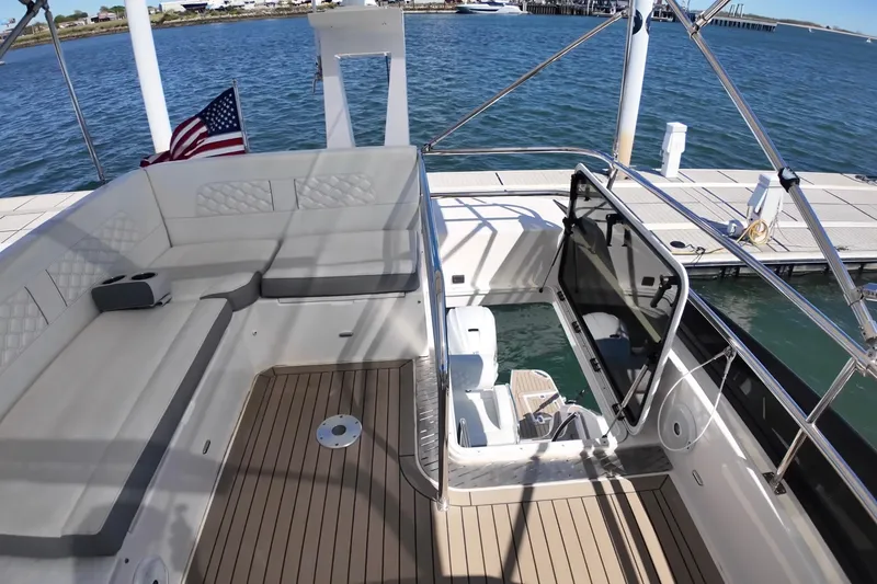 Slide: The Image of 2022 Regal 42 FXO yacht interior with seating and open deck, docked by the water. - 11