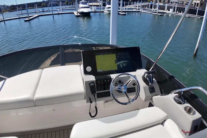 Slide: The Image of 2022 Regal 42 FXO yacht helm with modern navigation system and luxurious seating. - 13