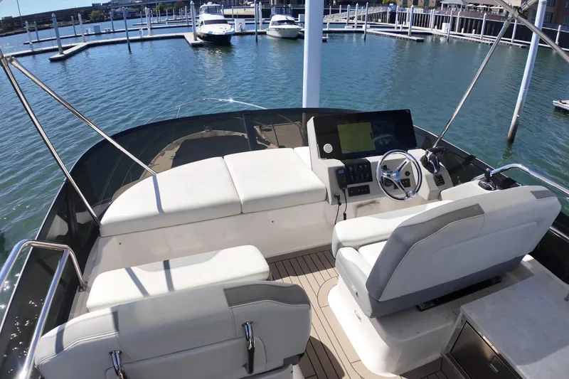 Slide: The Image of Flybridge of 2022 Regal 42 FXO yacht with helm and seating, docked in marina. - 14