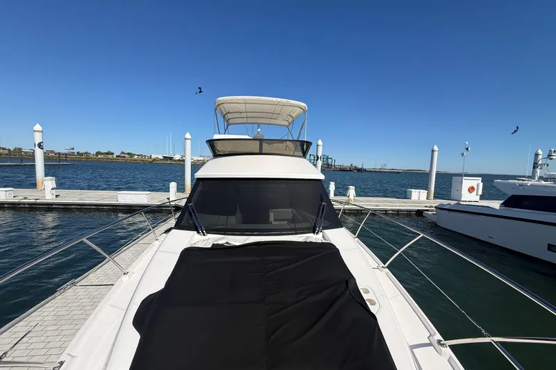 Slide: The Image of 2022 Regal 42 FXO yacht docked at marina with clear blue sky. - 16
