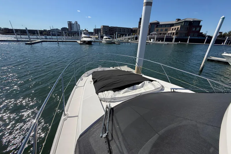 Slide: The Image of 2022 Regal 42 FXO yacht docked in a marina with cityscape background. - 18