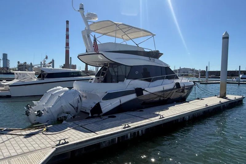 Slide: The Image of 2022 Regal 42 FXO yacht docked at marina under clear blue sky. - 2